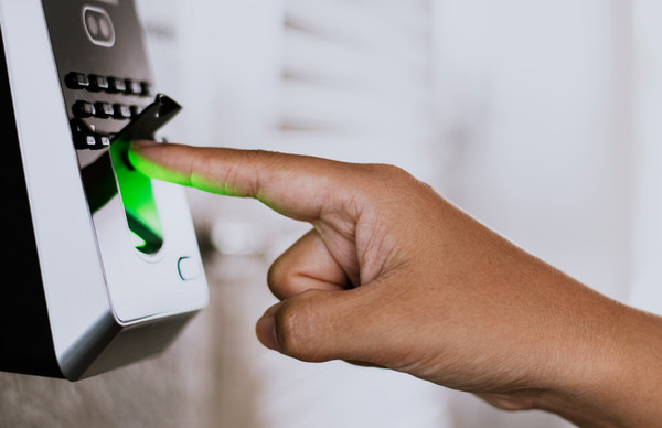A finger pressed to an illuminated biometric fingerprint access-control scanner